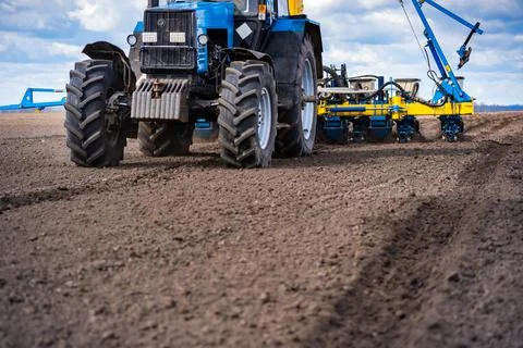 Sowing work in the field in spring. Tractor with seeder Stock Photos