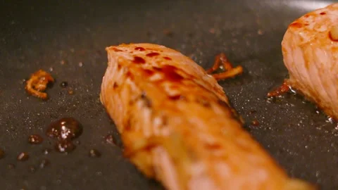 Soy Sauce Falling onto Salmon Fillets in a frying pan in Slow Motion Stock Footage 335274705