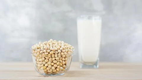 Soybean in a bowl and soy milk on a wooden background. Stock Photos
