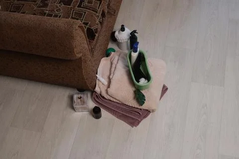 Spa and wellness items arranged on towels next to a sofa Stock Photos