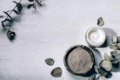 Spa background with natural clay mask and cream with eucalyptus leaves on a Stock Photos