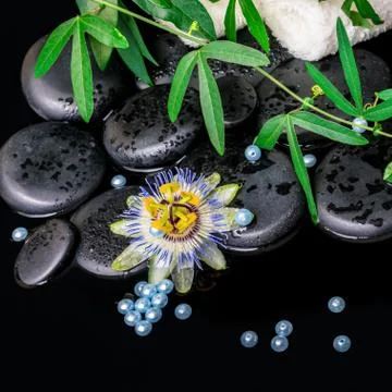 Spa background of passiflora flower, branches, towels, zen basalt stones with Stock Photos