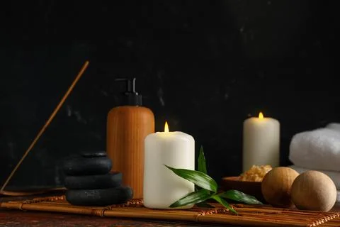 Spa composition with bamboo mat, burning candle and stones on red grunge back Stock Photos