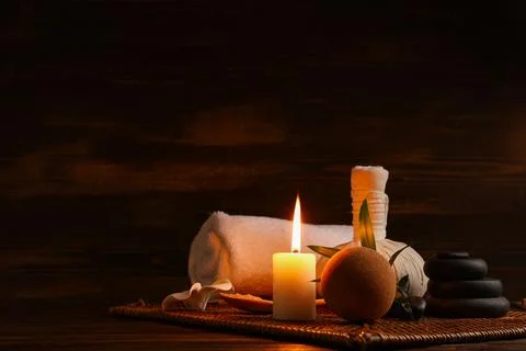 Spa composition with burning candle, herbal bag and bath bomb on wooden backg Stock Photos