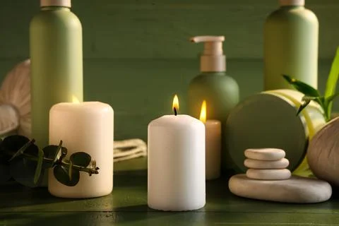 Spa composition with burning candles and stones on green wooden background, c Stock Photos