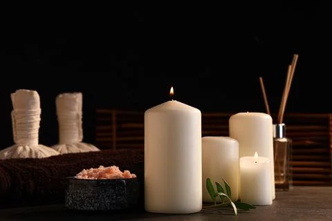 Spa composition with burning candles and bowl of sea salt on black grunge bac Stock Photos