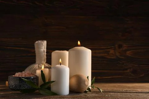 Spa composition with burning candles, green leaves and massage balls on woode Stock Photos