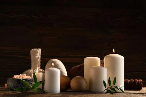 Spa composition with burning candles, green leaves and massage balls on woode Stock Photos