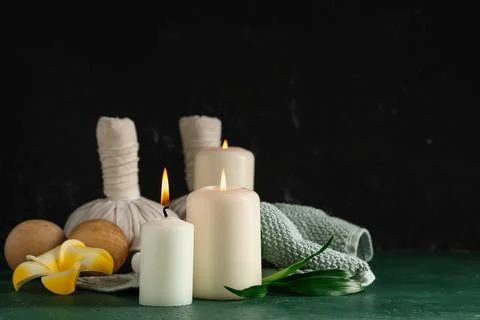 Spa composition with burning candles, towel and flower on green grunge backgr Stock Photos