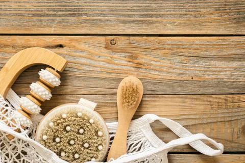Spa composition with massage brushes and hygiene items in a mesh shopping bag. Stock Photos