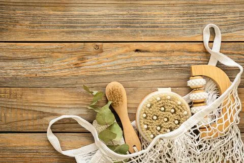 Spa composition with massage brushes and hygiene items in a mesh shopping bag. Foto stock