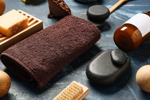 Spa composition with stones and bath supplies on blue grunge background, clos Stock Photos