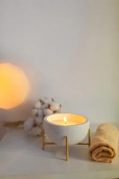 Spa composition in with towels, a candle burning in a bowl and a branch of co Stock Photos
