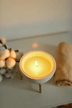 Spa composition in with towels, a candle burning in a bowl and a branch of co Stock Photos