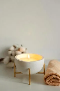 Spa composition in with towels, a candle burning in a bowl and a branch of co Stock Photos