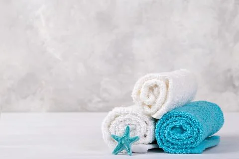 Spa composition with white and blue soft rolled cotton towels and star fish c Stock Photos
