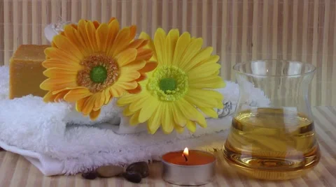 Spa Concept with flowers,massage oil,towel,soaps and candle on bamboo background Stock Footage