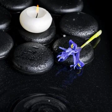 Spa concept top down of iris flower, candles and black zen stones  Foto stock