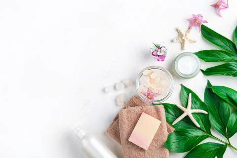 Spa elements, towel, soap, salt, cream and flowers on a white background. Stock Photos