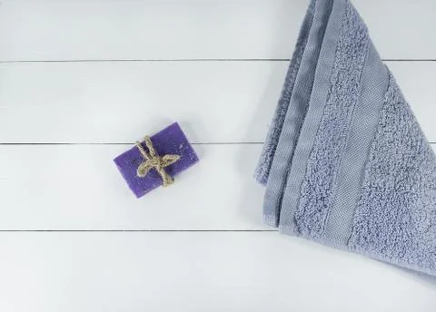 Spa flatlay bath and violet towel on wooden background. Handmade soap lavender. Stock Photos
