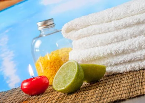 Spa massage border background with towel stacked,red candle and lime on swimm Stock Photos