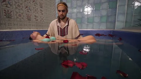 Spa master in the pool carries out a procedure for relaxing a woman Stock Footage 157971102