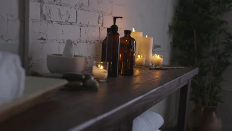 Spa or bathroom cozy decor on shelf, cosmetic falcons and burning candles Stock Footage 208753430