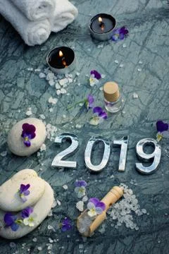 Spa set for 2019 with bath salt and lighted candles, adorn the flowers of vio Stock Photos