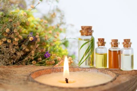 Spa set with burning candle, essential oils in bottles, herbs and flower Stock Photos
