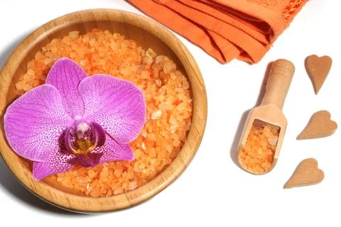 Spa set of orange bath salts in a wooden spatula and bowl, towel and hearts o Stock Photos