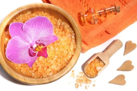Spa set of orange bath salts, towels and a pink orchid Stock Photos