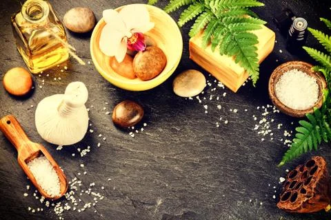 Spa setting with soap bar, herbal massage ball and essential oil Stock Photos