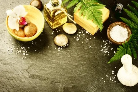 Spa setting with soap bar, herbal massage ball and essential oil Stock Photos