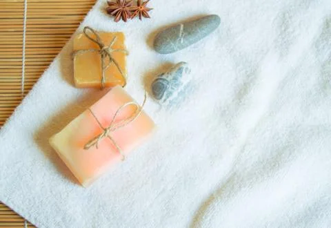 Spa setting with white towel, handmade soap, stones, on natural bamboo backgr Stock Photos
