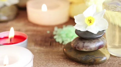Spa still life containing bath salt, rocks, massage oil, candles and flowers 스톡 동영상 49586396