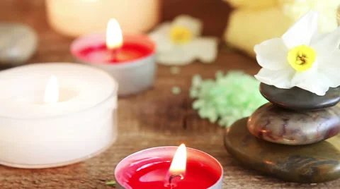 Spa still life of rocks, bath salt, massage oil and flowers Stock Footage 49586384