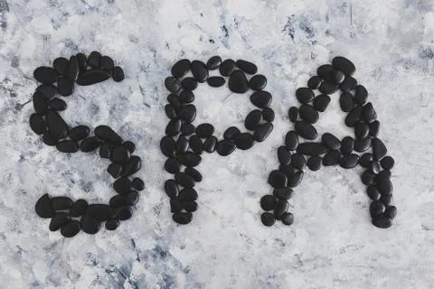 Spa text made with zen pebbles on grey concrete surface Stock Photos