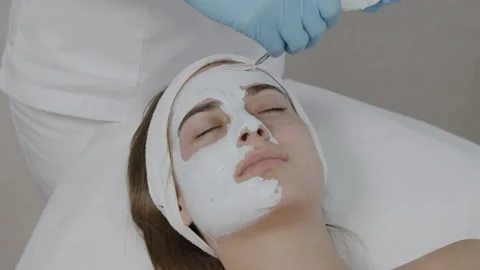 Spa therapist applying mud mask on woman face Stock Footage 165792974