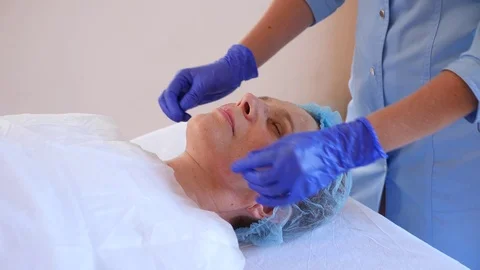 Spa therapy for elderly woman receiving facial mask. 4k. Slow motion. Reception Stock Footage