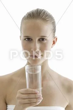A spa treatment centre. A young woman drinking a glass of water for hydration. Stock Photos