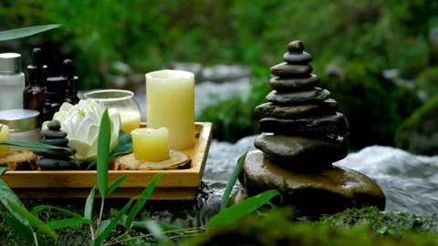 Spa wellness setup with candles and balanced rocks stream Stock Footage 332278834