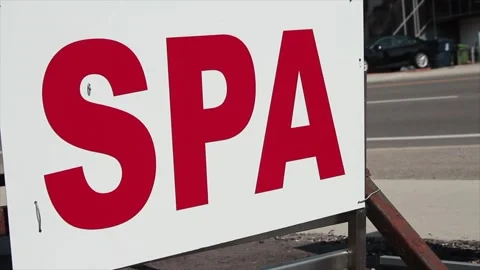 Spa writing caption text sign signboard with calm road behind, red on white Stock Footage 249101076