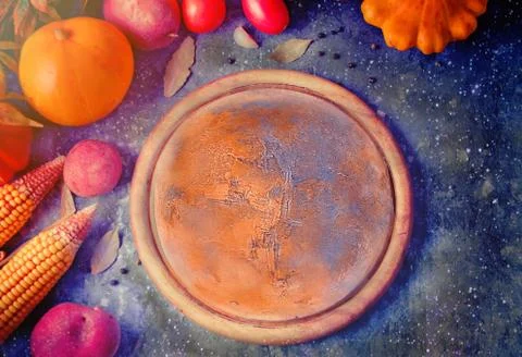 Space composition. Cutting board like the planet Mars, autumn leaves, vegetab Stock Photos
