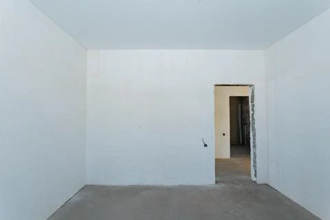 The space is an empty, minimalistic room characterized by stark white walls.. Stock Photos