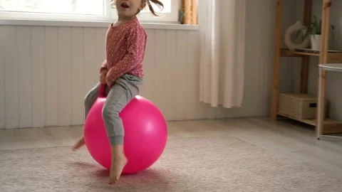 Space hopping child. Active fun. Happy kid jumping on bouncing ball. Bouncing on Stock Footage 267678175