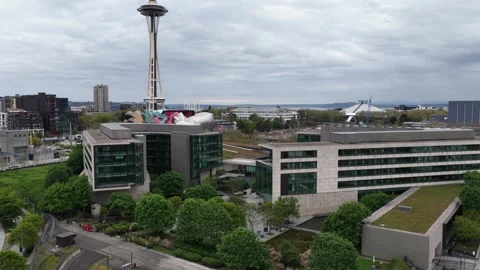 Space Needle towers above modern glass office complex with sculpture artwork Vídeo Stock 338984150