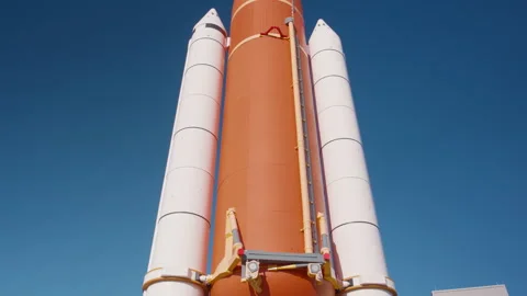 Space shuttle external tank and solid rocket boosters against blue sky Stock Footage 337904116