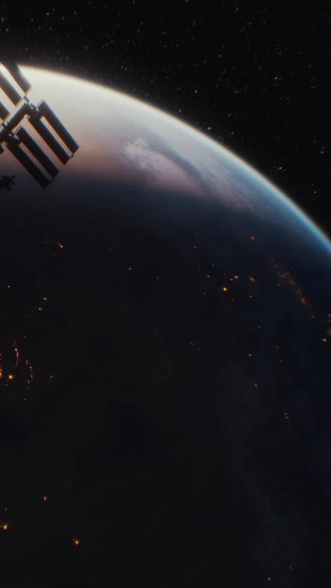 Space station orbits Earth at night with visible city lights below Video stock 344960711