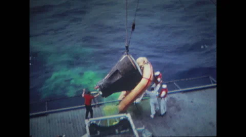 Spacecraft getting pulled up by crane on ship deck Stock Footage