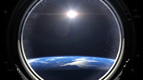 The spaceship is approaching the earth. A view through the porthole of a Stock Footage 114323445
